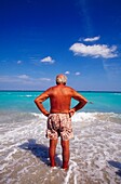 Senior Man Standing In Ocean, Rear View