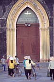 People With Bicycles In Front Of Church Entrance