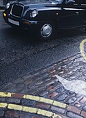 Black Cab And Cobbled Pavement