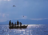 Fischer ziehen Fischernetze auf einem kleinen Boot auf dem Chilwa-See