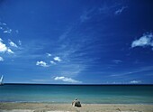 Tourist Sun-Bathing On Idyllic Sandy Beach