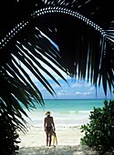 Frau am tropischen Strand stehend