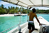 Mann in Schnellboot nähert sich der Insel Kapas