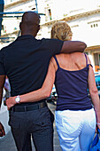Embracing Couple Walking On Street,Rear View, Cuba