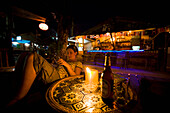 Young Woman Sitting In Bar At Night In Vang Vieng, Laos