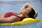 Junge Frau trägt Bikini, Sonnenbaden im Schwimmbad, Riviera Maya, Yucatan-Halbinsel, Staat Quintana Roo, Mexiko