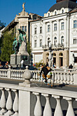 Fahrradfahrer auf dreifacher Brücke, Ljubljana, Slowenien