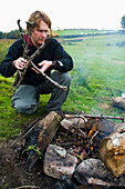 Mann bereitet Lagerfeuer im Feld vor, Dartmoor National Park, Postbridge, Yelverton, Devon, Großbritannien