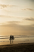 Couple Walking On Beach At Sunset