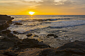 Goldener Sonnenuntergang über dem Meer mit Blick auf die Küstenlinie; Insel Bali, Indonesien