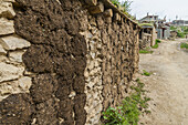 Tibetische Hauswand, die Einheimischen kleben Kuhkot zum Trocknen auf und verwenden ihn als Brennmaterial zum Erhitzen von Wasser oder Essen; Litang, Sichuan, China