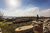 A Young Man Stands On The Base Of A Pillar At A Ruins Site; Sabasita, Samaria, Israel