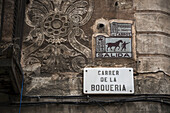 Schild für die Boqueria-Straße an einer dekorativen, geschnitzten Steinmauer; Barcelona, Katalonien, Spanien.