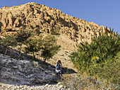 A Young Woman Walks On A Trail Through The Rugged Hills Of Ein Gedi Nature Reserve, Dead Sea District; South Region, Israel