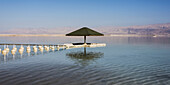 Ein Regenschirm, Bojen und ein Dock im Toten Meer; Südbezirk, Israel