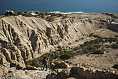 Eine junge Frau fotografiert auf einem Pfad in der Region des Toten Meeres, mit dem Toten Meer im Hintergrund; Süddistrikt, Israel.
