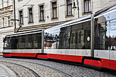 Ein moderner elektrischer Zug bahnt sich seinen Weg über Kopfsteinpflaster; Prag, Tschechien