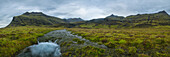 Panoramablick auf einen Schmelzwasserstrom, der von den Bergen entlang der Südküste Islands kommt; Island