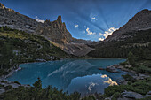 Sonnenstrahlen scheinen durch den Spätnachmittagshimmel über dem Sorapiss-See in den italienischen Dolomiten; Cortina, Italien