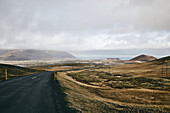 An Asphalt Road Along The Coast Under A Cloudy Sky; Iceland