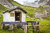 Kleines, historisches Heiligtum im Val Veni mit Rifugio Elisabetta im Hintergrund, Alpen; Aostatal, Italien.
