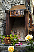 Old wooden bar equipment with flowers in pots, Dolonne, near Courmayeur; Aosta Valley, Italy