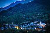 View of Courmayeur city center and mountains at dusk; Courmayeur, Aosta Valley, Italy