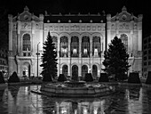 Exterior of a building illuminated at nighttime by light, a frozen pool and fountain in the foreground; Budapest, Budapest, Hungary