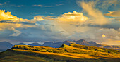 Sonnenlicht beleuchtet die bergige Landschaft und die Wolken; Isle of Skye, Schottland