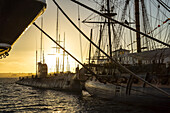 Schiff und Segelboot im Hafen bei Sonnenuntergang; San Diego, Kalifornien, Vereinigte Staaten von Amerika.