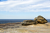 Felsen am Ufer des Bondi Beach und die blaue Tasmanische See im Südpazifik; Little Bay, New South Wales, Australien.