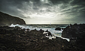 Zerklüftete Landschaft entlang der Atlantikküste mit einer Yacht in einem Sturm; Insel Sao Miguel, Azoren, Portugal.