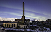 The abandoned herring factory with northern lights above it; Djupavik, West Fjords, Iceland
