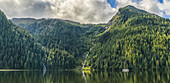 Blick auf das Gebiet des Great Bear Rainforest mit einem Segelboot auf dem Wasser; Hartley Bay, British Columbia, Kanada.