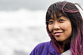Nahaufnahme einer philippinischen Frau mit rosa gefärbtem Haar; Island