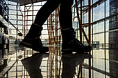 Feet walking and reflected on glossy floor of the terminal building, Beijing Capital International Airport; Beijing, China