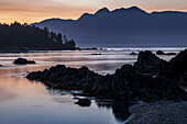 Dusk falls over Vancouver Island viewed from an islet in Nuchatlitz Provincial Park; British Columbia, Canada