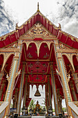 Buddha statue in red and gold temple; Bangkok, Thailand