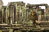 Statue in foreground of ruined Bayon temple, Angkor Wat; Siem Reap, Siem Reap Province, Cambodia