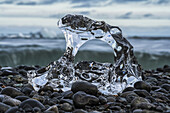 Small piece of melted glacial ice on the shore of the ocean near Jokulsarlon, South Coast of Iceland; Iceland