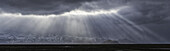 Dramatische Sonnenstrahlen brechen durch die Wolken entlang der Südküste Islands und schaffen eine erstaunliche Szene; Island