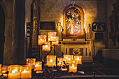 Beleuchtete Kerzen und Kunstwerke in einer Kathedrale; Italien