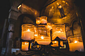 Beleuchtete Kerzen und Kunstwerke in einer Kathedrale; Italien