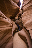 Mann steht in einem Slot Canyon, bekannt als Canyon X, in der Nähe von Page; Arizona, Vereinigte Staaten von Amerika