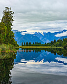 Spiegelung von Bäumen und Bergen im ruhigen Matheson Lake; Südinsel, Neuseeland