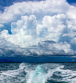Wake from a boat in the ocean with dramatic storm clouds; Malolo Island, Fiji
