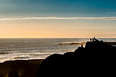 Freunde genießen die Aussicht in der Nähe des Reykjanes-Leuchtturms bei Sonnenuntergang, Reykjanes-Halbinsel; Island