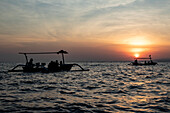 Indonesian jukung, traditional wooden outrigger canoe at sunrise; Lalang, Bali, Indonesia