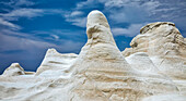 White rock formations and blue sky with cloud; Milos, Greece