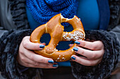 Woman eating a pretzel; New York City, New York, United States of America